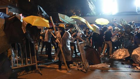 Die Demonstranten haben in Erinnerung an die Proteste von 2014 aufgespannte Regenschirme mit dabei, als sie gegen die Einflussnahme Pekings auf die Straße gehen.