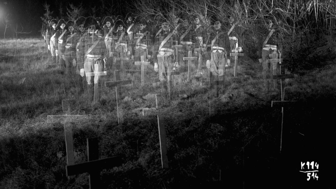 Im Still aus "Katzensteg" sind Kreuze auf einem Friedhof zu sehen, überlagert per Doppelbelichtung mit Skelettsoldaten.
