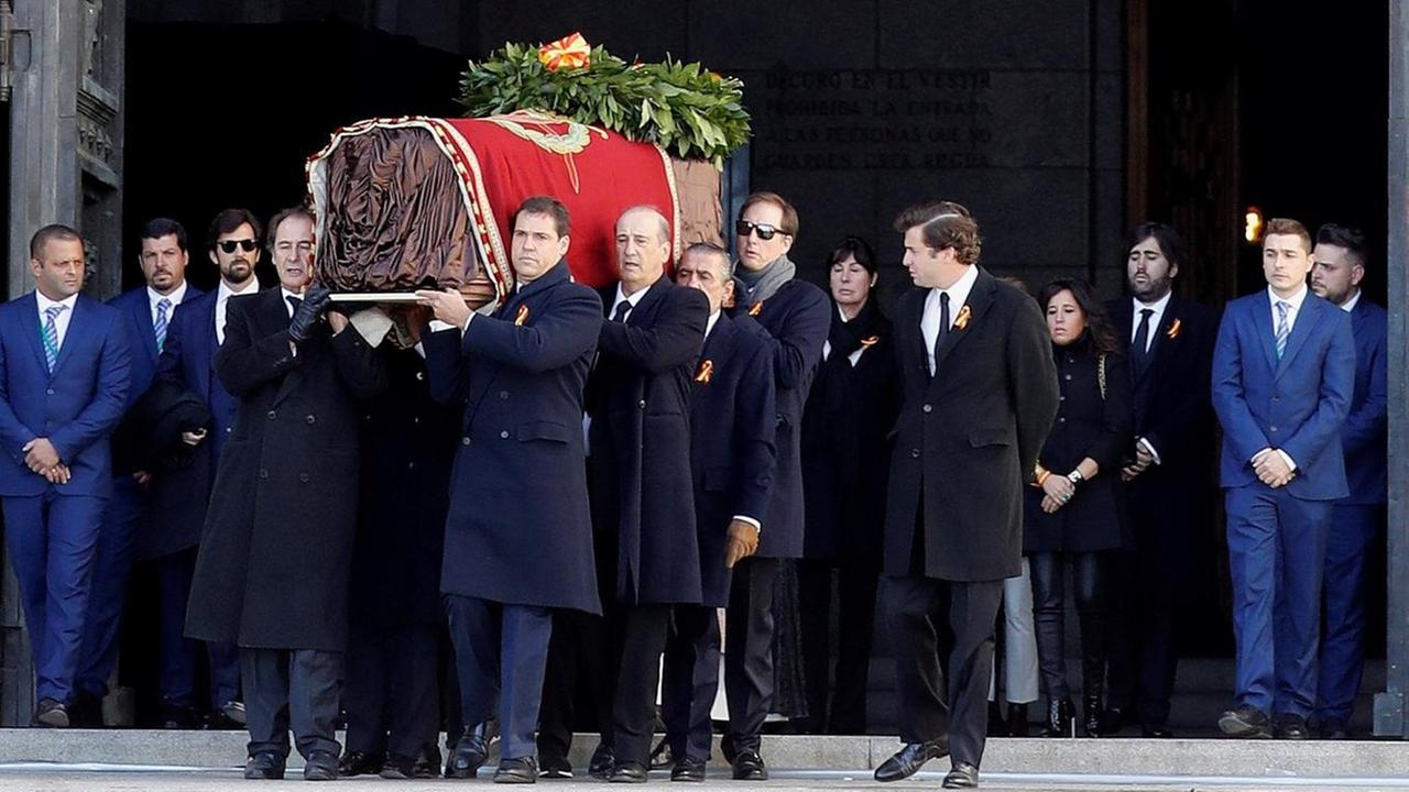 Verwandte des spanischen Diktators Francisco Franco tragen den Sarg mit seinen sterblichen Überresten aus einem Mausoleum.