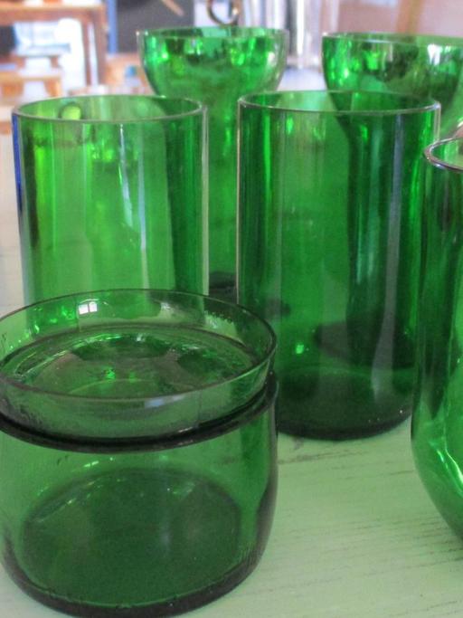 Auf einem Tisch stehen mehrere recycelte, flaschengrüne Gläser. (Bild von Autor Peter Backof)