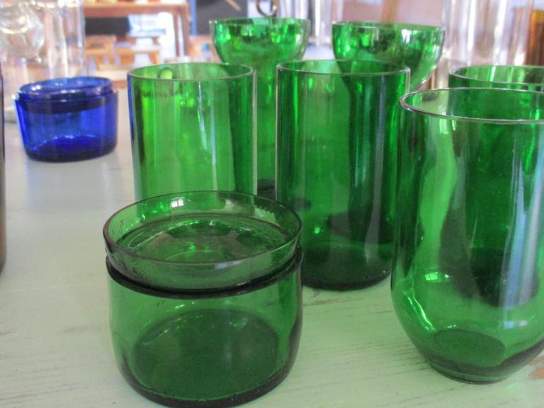 Auf einem Tisch stehen mehrere recycelte, flaschengrüne Gläser. (Bild von Autor Peter Backof)