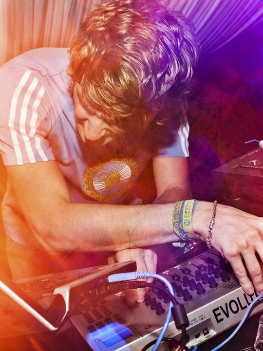 Ein DJ an einem Mischpult in einem Club.