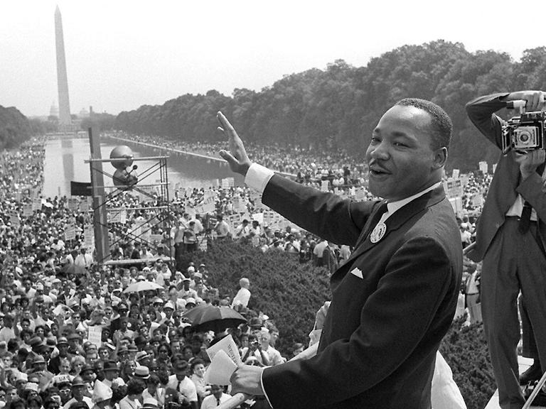 Martin Luther King am 28. August 1963 in Washington, D. C. winkt den Demonstranten zu.