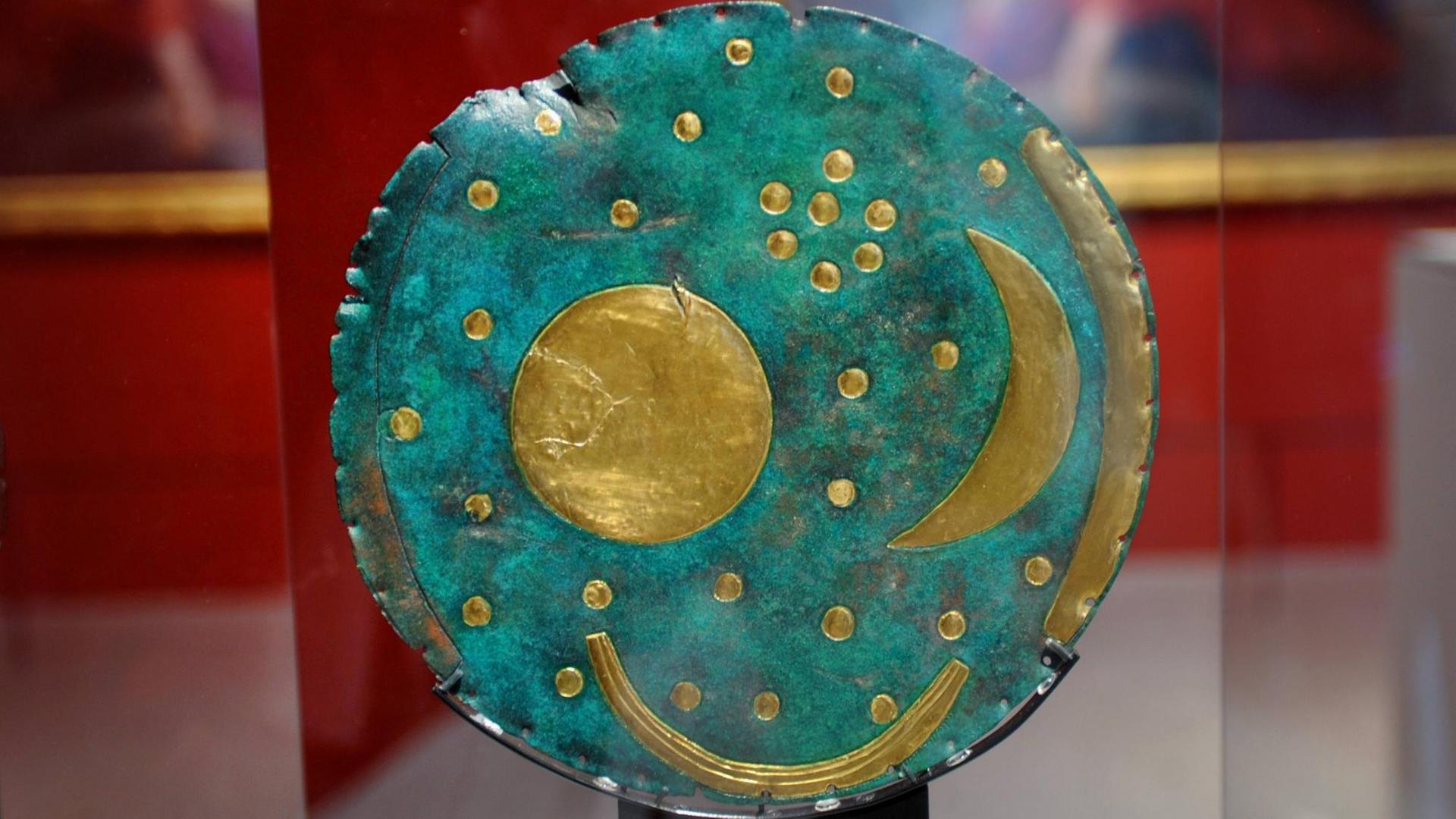 Auf der runden Bronze-Platte sind Sonne, Mond und Sterne aus Gold befestigt