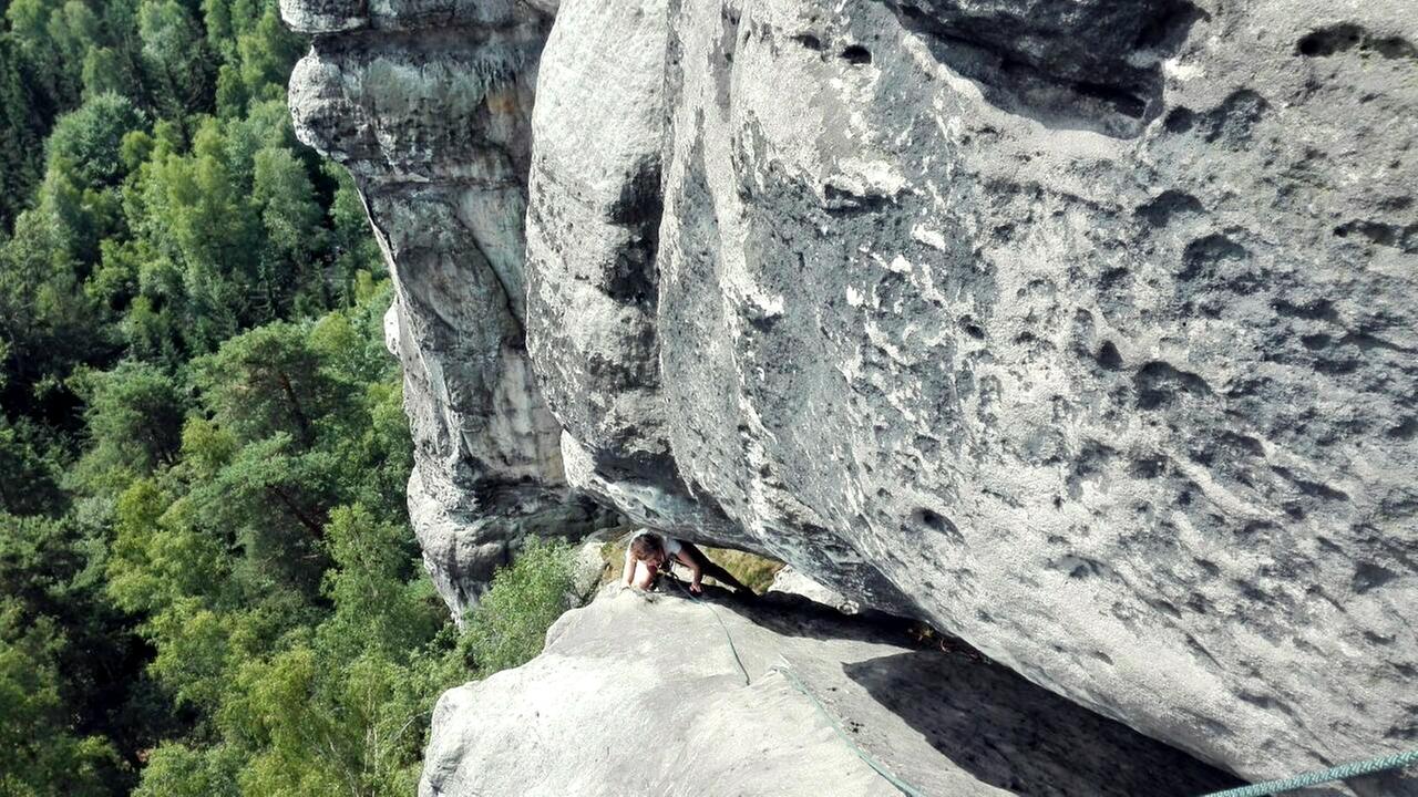 Annette Kammerer klettert durch einen Felsvorsprung.