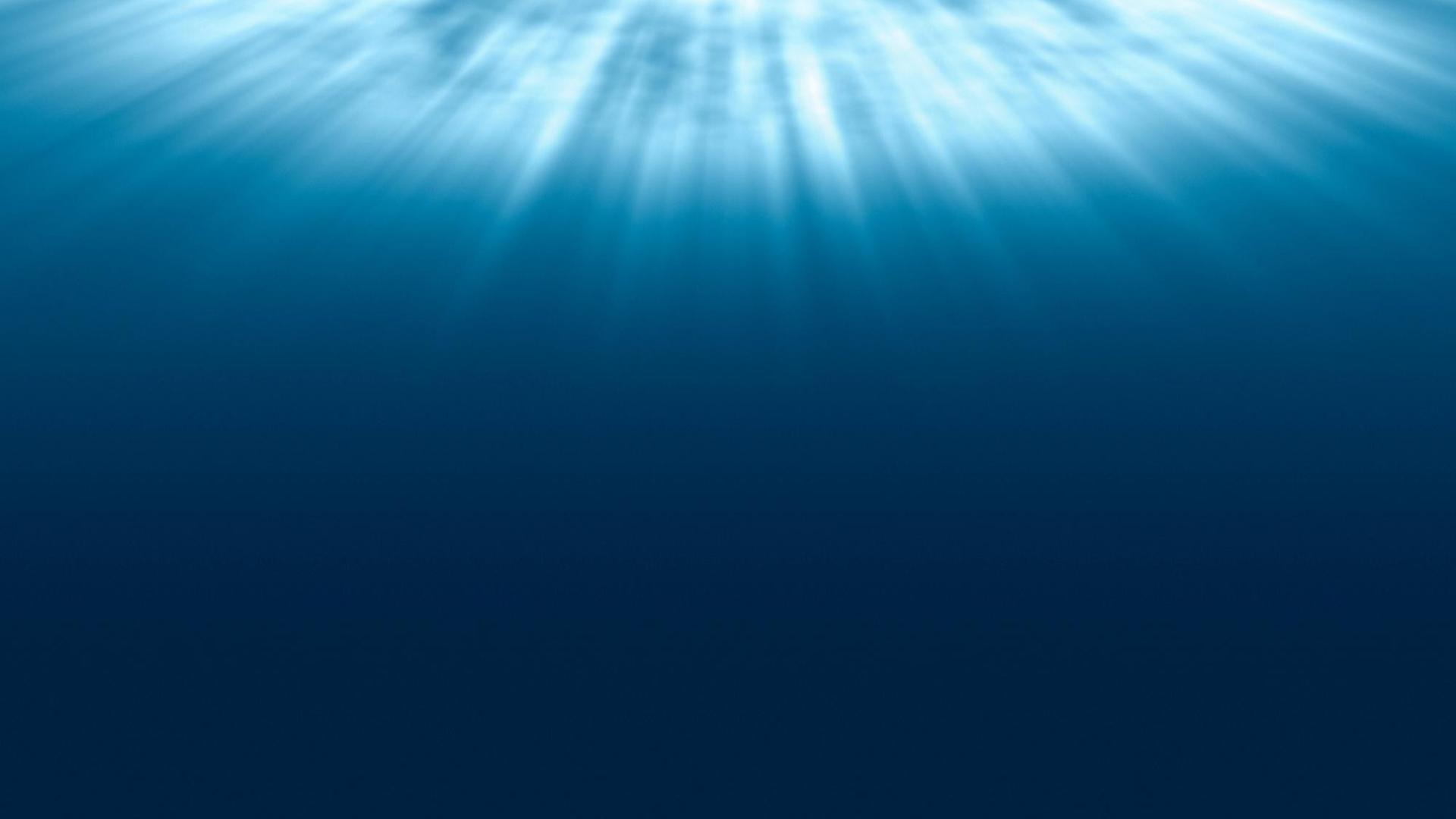Ein Blick zur Wasseroberfläche zeigt, wie sich das Licht strahlenförmig im blauen Wasser ausbreitet.