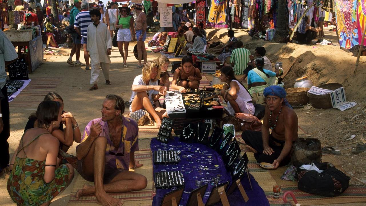 Touristen und Verkäufern auf dem Hippie-Flohmarkt in Anjuna, Goa, Indien.