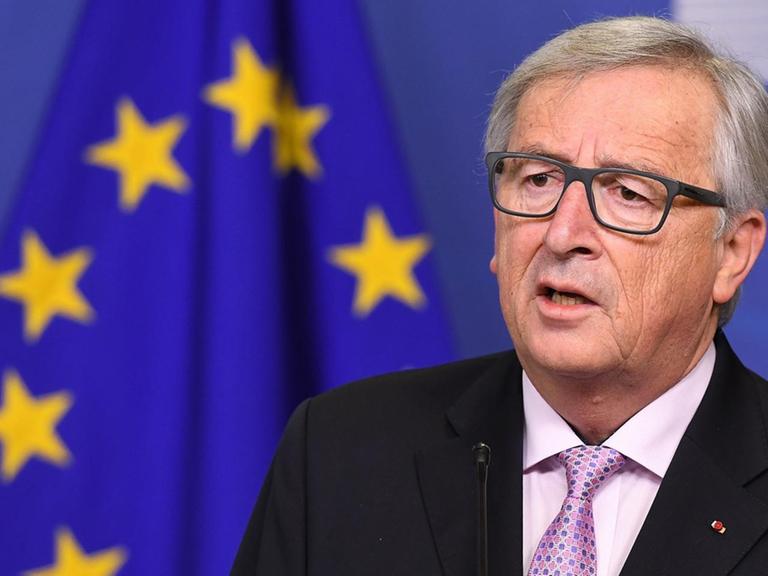 EU-Kommissionschef Jean-Claude Juncker steht neben einer Europa-Fahne-