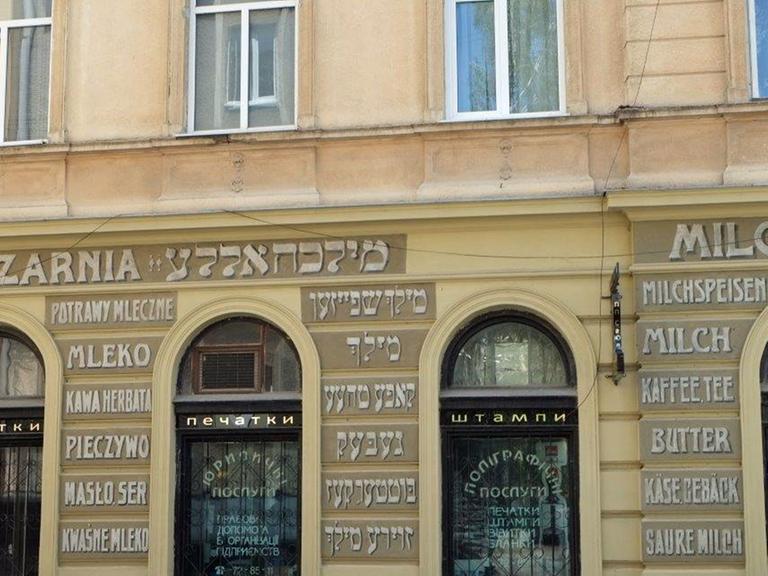Ein alte Beschriftung, liebevoll nachgemalt, an einer Hauswand in Lemberg: Neben dem polnischen "Mleczarnia" und dem deutschen "Milchhalle" stehen hebräische Zeichen.