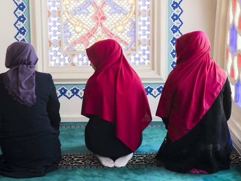 Drei junge Frauen beten in der Sehitlik Moschee in Berlin Neukölln, 2017.