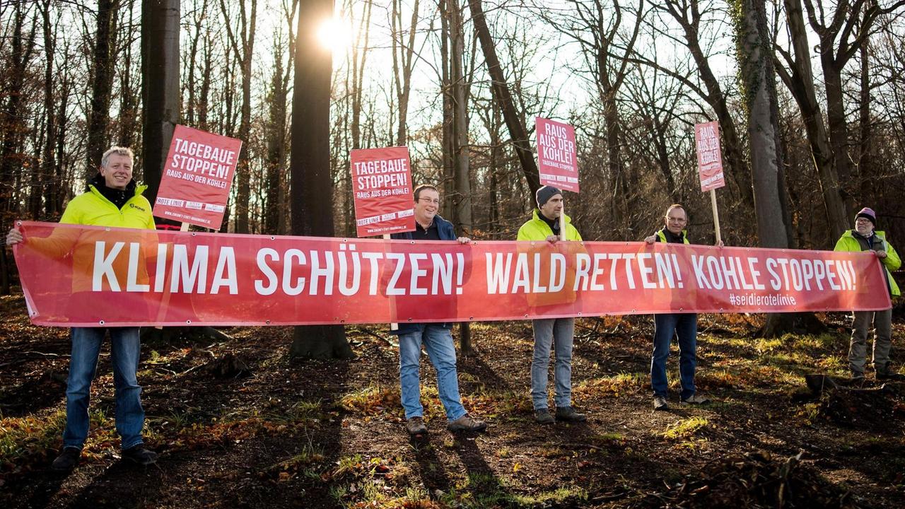 Die Demonstranten in gelben Warnwesten halten ein Transparent mit der Aufschrift "Klima schützen! Wald retten! Kohle stoppen!". 