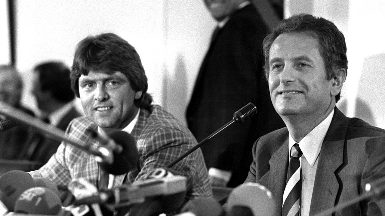 Der stellvertretende Kieler Regierungssprecher Herwig Ahrendsen (l) und Ministerpräsident Uwe Barschel am 18.09.1987 während einer Pressekonferenz in Kiel. 
