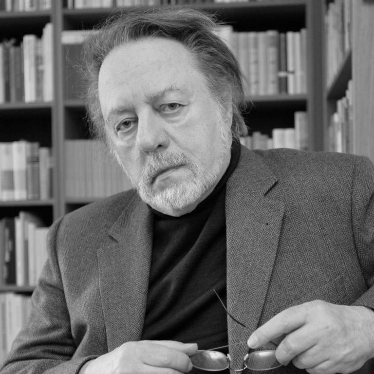 Der Schriftsteller Ror Wolf sitzt am Dienstag (26.02.2008) in seiner Wohnung in Mainz vor einem Bücherregal auf einem Sofa.