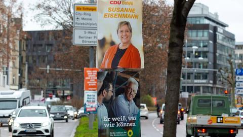 Auf Wahlplakaten in Stuttgart sind die Spitzenkandidatin der CDU, Susanne Eisenmann, und der Spitzenkandidat der Grünen, Winfried Kretschmann, zu sehen.