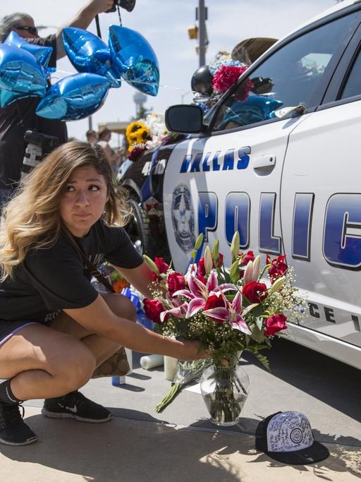 Eine Frau und ihre Tochter legen in Dallas Blumen an einem Polizeiauto nieder, um der getöteten Polizisten zu gedenken