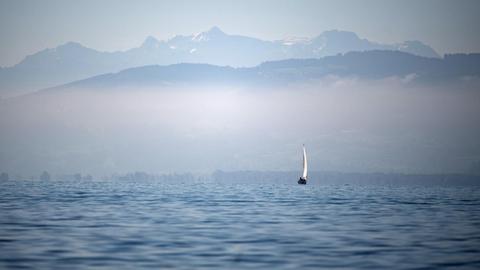 Ein Segelboot fährt auf dem Bodensee vor dem Alpenpanorama, aufgenommen im September 2019