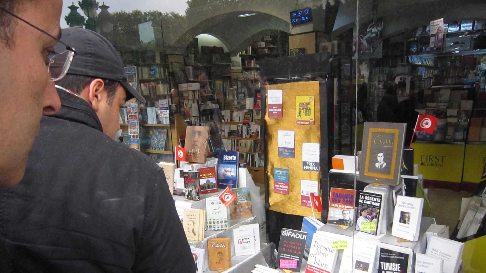 Zwei Passanten betrachten am 20.01.2011 die Auslage eines Buchladens in Tunis. Erstmals liegen zahlreiche bislang verbotene Bücher in der Auslage.