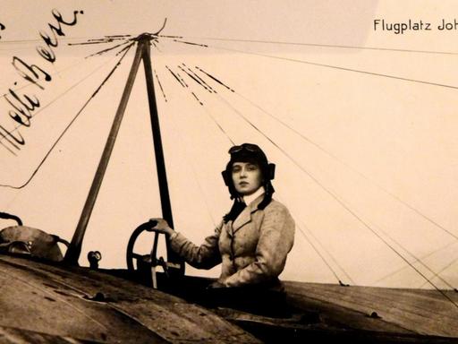 Signierte Postkarte mit einem Foto von von Melli Beese (1886-1925) in einem Flugzeug sitzend mit dem Hinweis "Frl. Beese auf Rumpler-Taube"