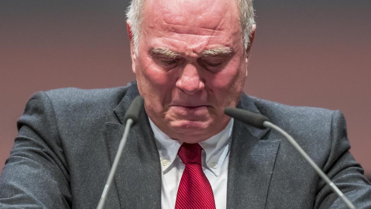 Uli Hoeneß senkt am Rednerpult den Kopf und hat Tränen in den Augen.