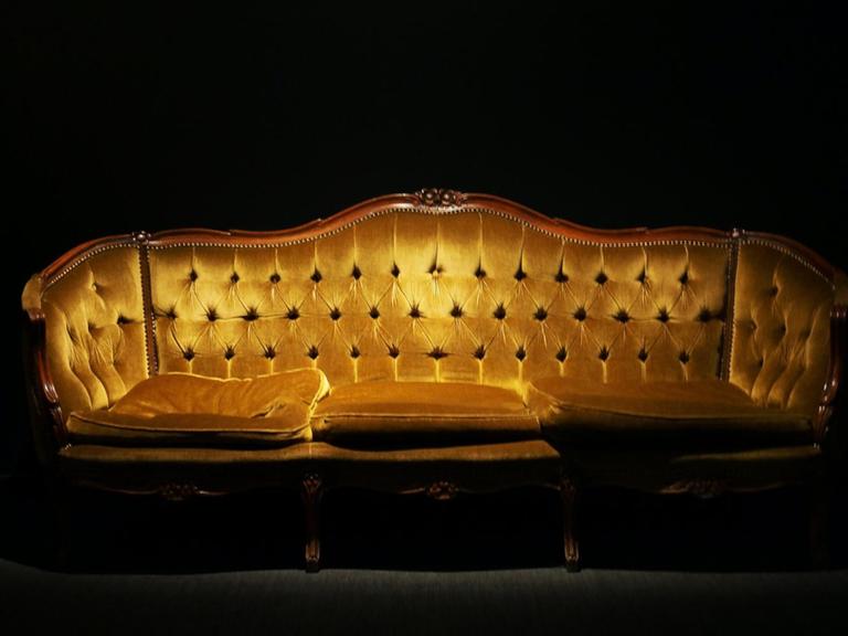 Eine goldenes Sofa in einem Raum.