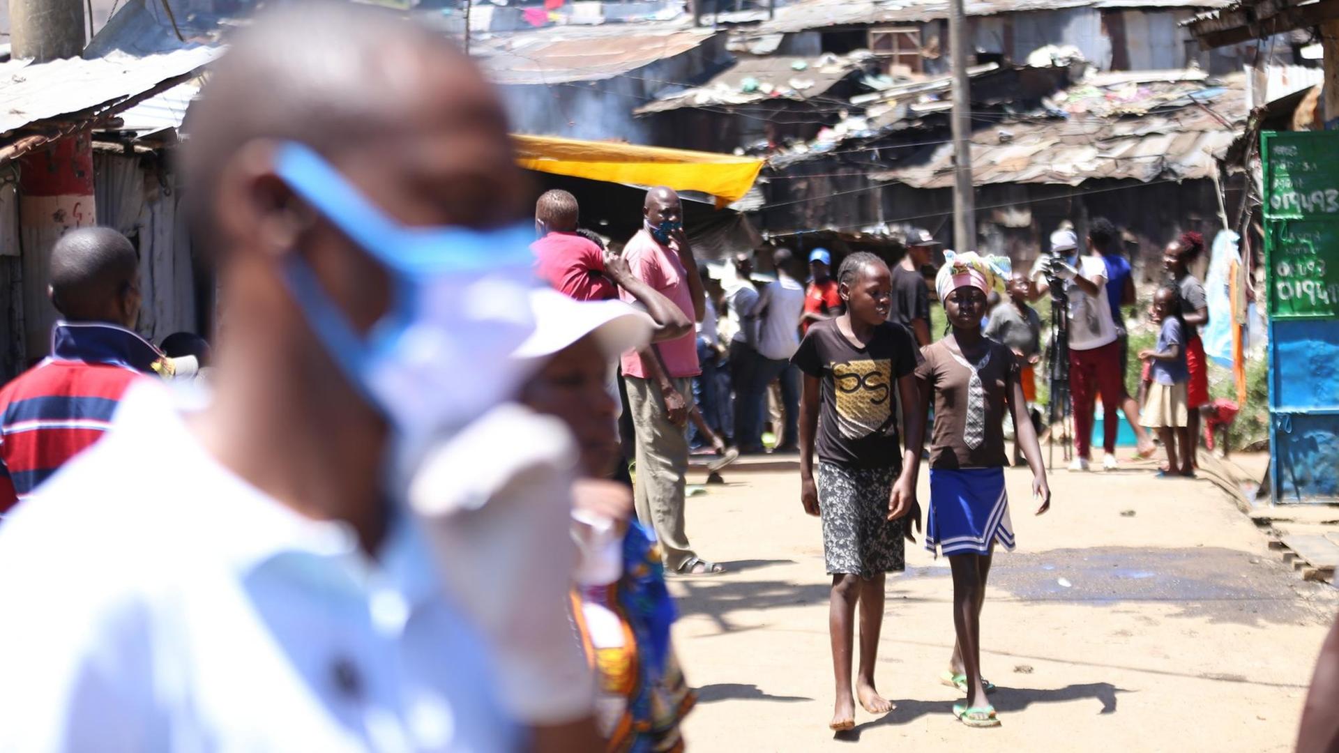 Menschen auf der Straße von Mathare, eine der zahlreichen informellen Siedlungen in der kenianischen Hauptstadt Nairobi