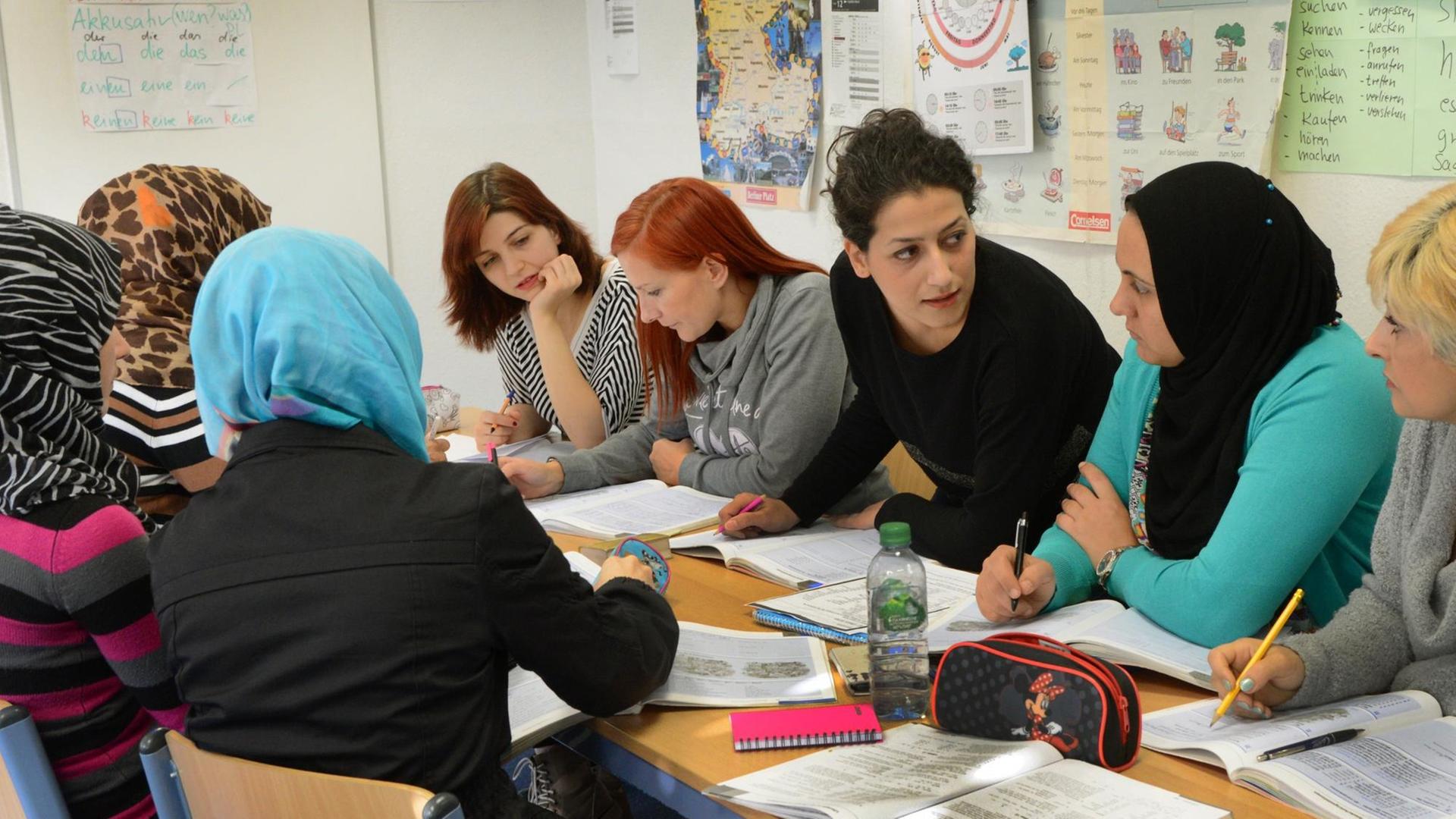 In einem Integrationskurs für Frauen im Language Coach Institut in Leipzig (Sachsen) sitzen Teilnehmer aus Syrien, dem Iran, Ägypten, der Ukraine und Polen im Deutsch-Unterricht bei der iranischen Dozentin Shamim Shahi Irani (Mitte), aufgenommen am 27.10.2015.