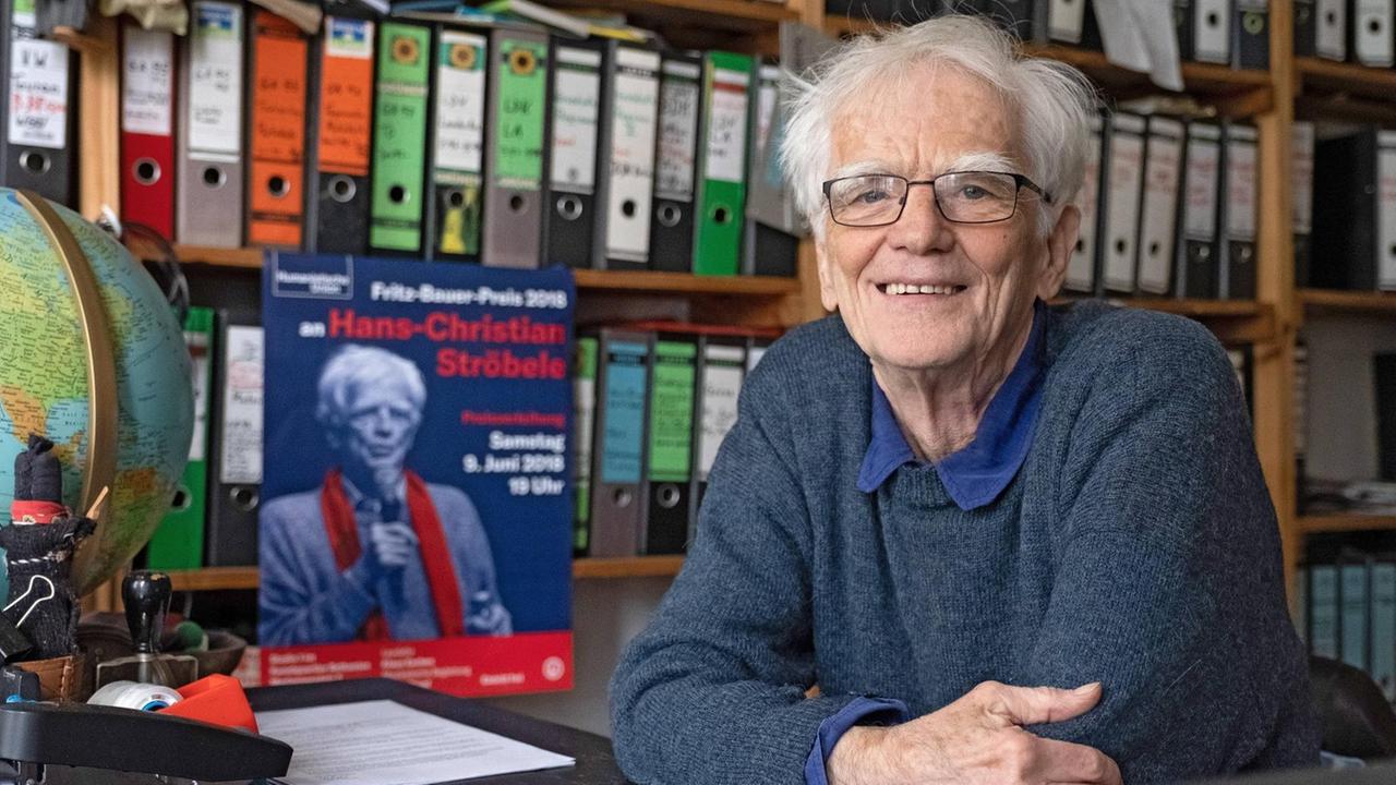 Der Grünen-Politiker Hans-Christian Ströbele sitzt in seiner Wohnung und blickt in die Kamera. Hinter ihm sind Regale voller Aktenordner.