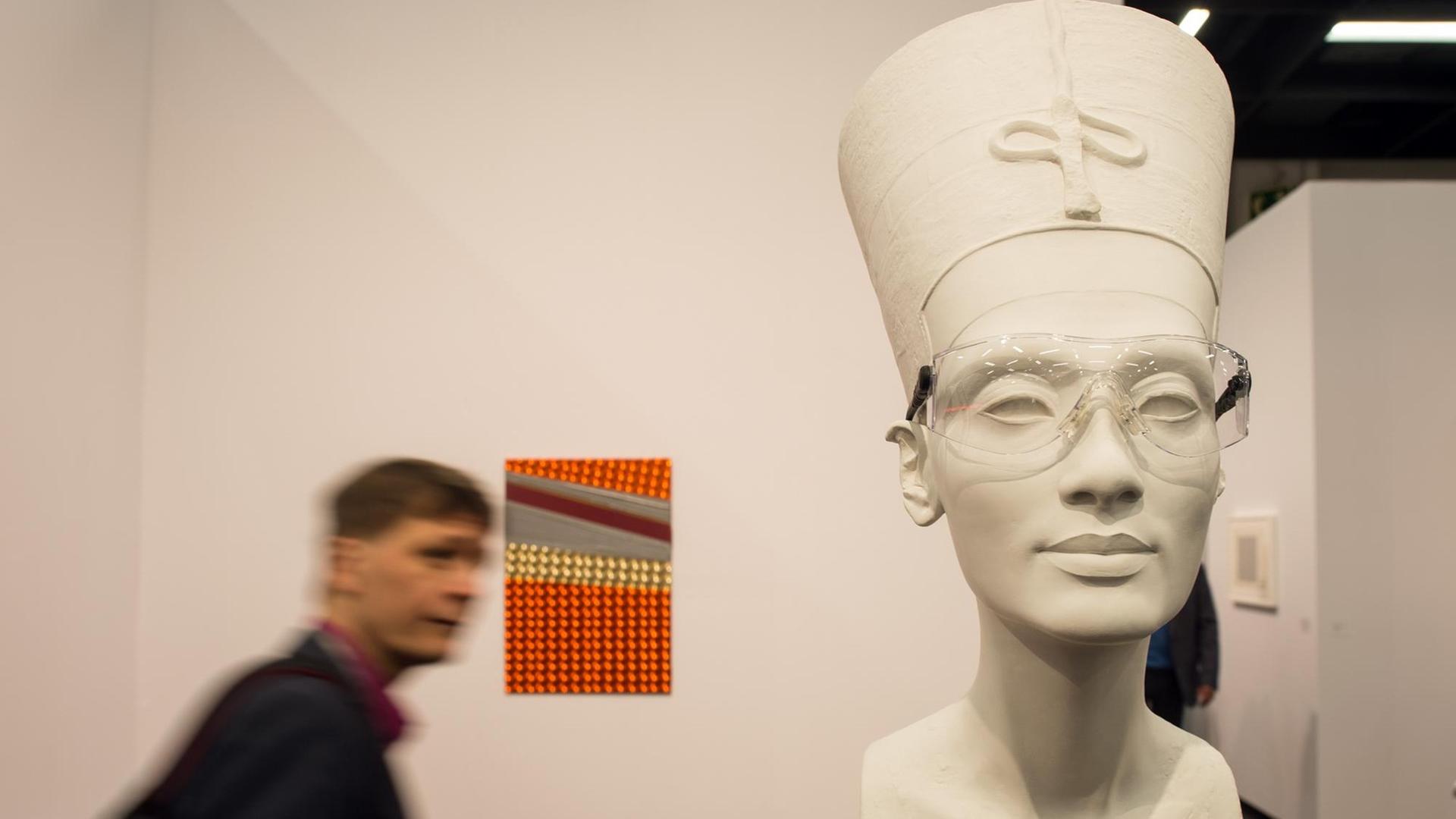 Ein Besucher geht in Köln (Nordrhein-Westfalen) am Kunstwerk "Nefertiti sculpture" aus dem Jahr 2015 von Isa Genzken vorbei.