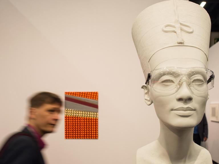 Ein Besucher geht in Köln (Nordrhein-Westfalen) am Kunstwerk "Nefertiti sculpture" aus dem Jahr 2015 von Isa Genzken vorbei.