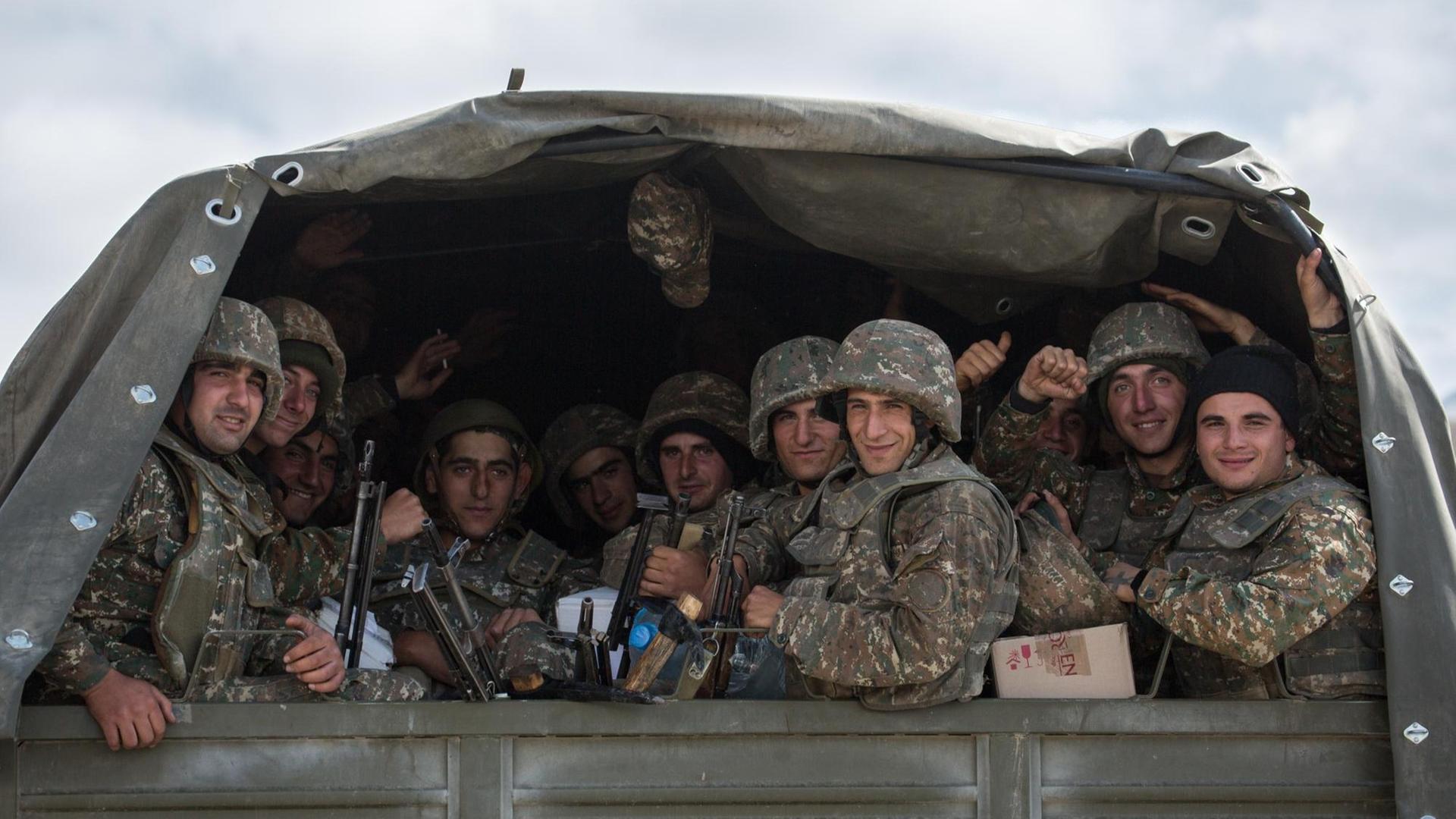 Blick auf einen LKW in dem mehrere Soldaten sitzen
