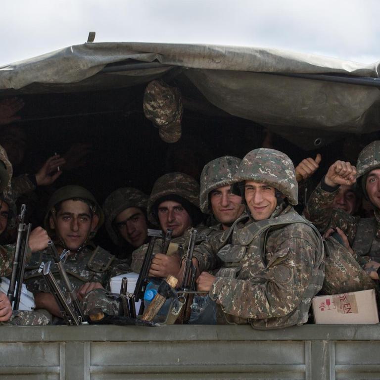 Blick auf einen LKW in dem mehrere Soldaten sitzen