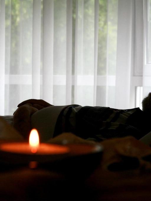 Ein verstorbener Bewohner liegt in seinem Bett im Christophorus Hospiz in München (Oberbayern), neben ihm auf einem Tisch eine brennende Kerze, aufgenommen am 05.06.2008. In einem Hospiz werden unheilbar kranke Patienten, die hier Bewohner genannt werden, palliativ versorgt. (!Veröffentlichung nur im Zusammenhang einer redaktionellen Berichterstattung zum Thema Hospiz). Foto: Tobias Hase dpa/lby +++(c) dpa - Report+++ | Verwendung weltweit
