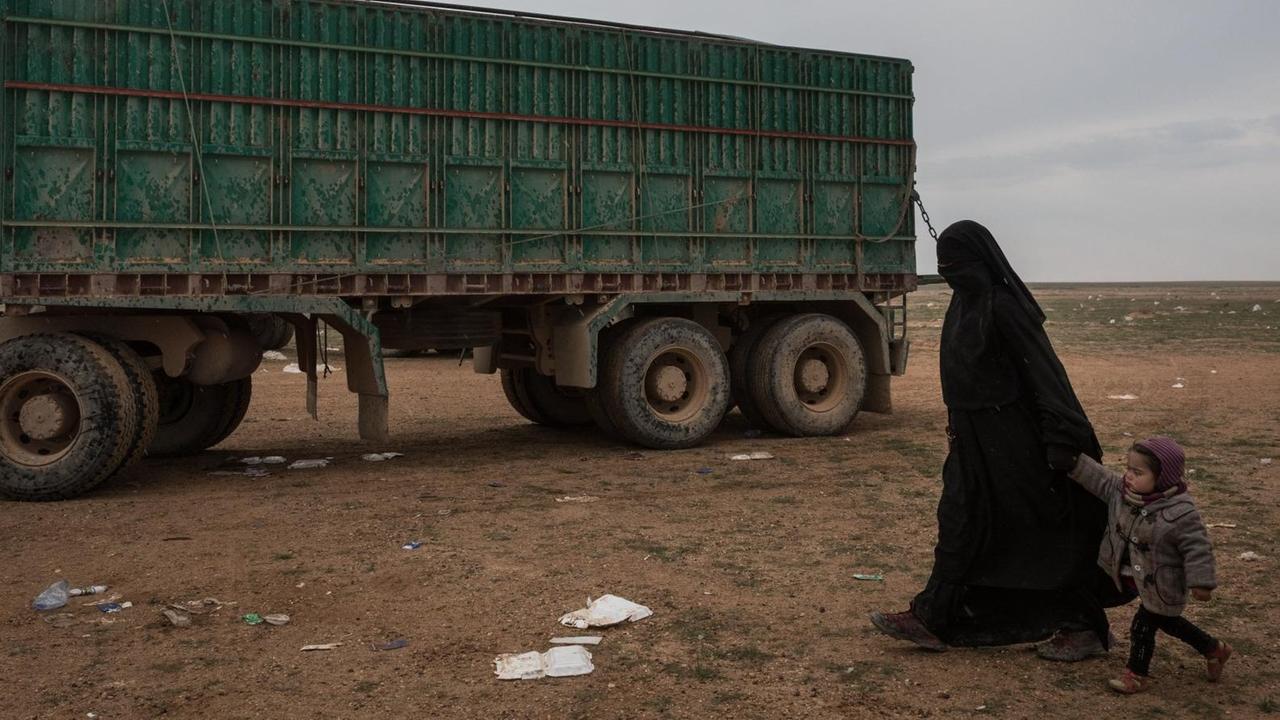 Eine Frau geht mit ihrem Kind durch das syrische Flüchtlingscamp Al-Hol