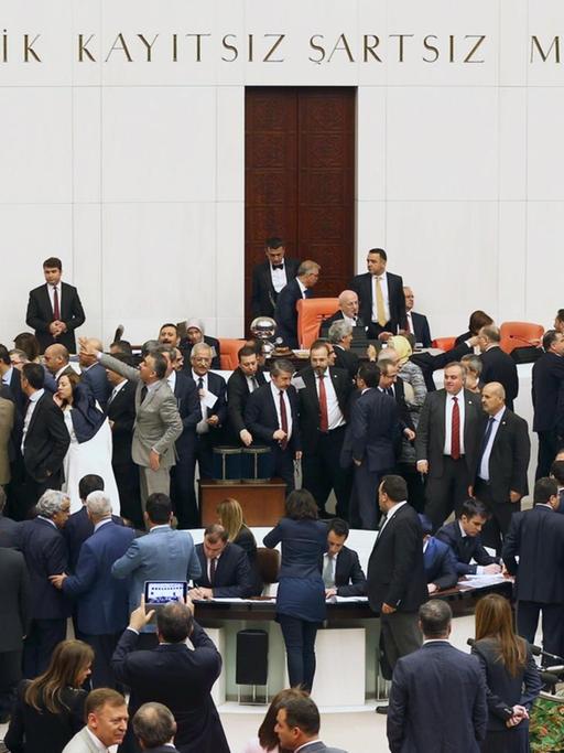Sie sehen den Parlamentssaal in der türkischen Hauptstadt Ankara, viele Abgeordnete reden dort miteinander.