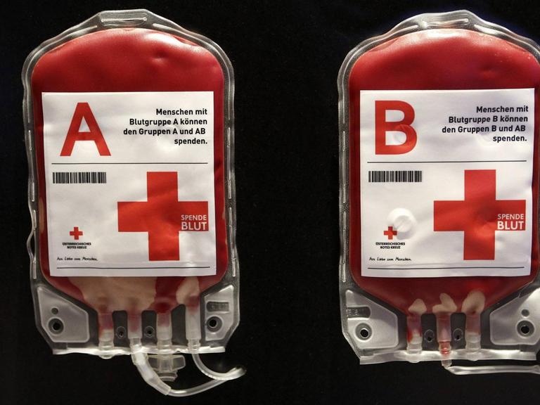 Zwei Blutkonserven vor schwarzem Hintergrund. Darauf wird erklärt, welche Blutgruppe welcher anderen spenden kann.