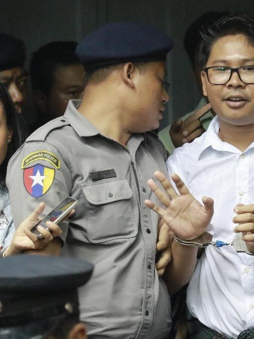 Der Reuters-Journalist Wa Lone stellt sich den Fragen von Medienvertretern, bevor er in ein Polizeifahrzeug steigt.