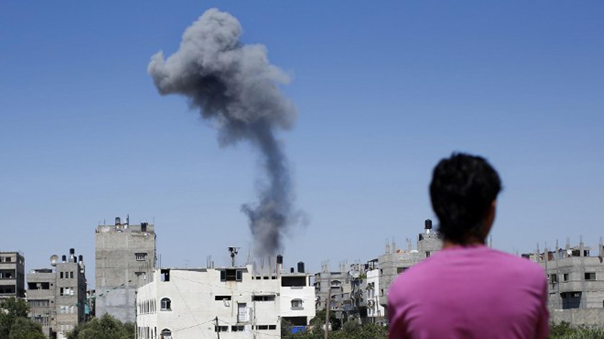 Ein Mann beobachtet aufsteigenden Rauch nach einem israelischen Luftangriff auf Ziele im Gazastreifen