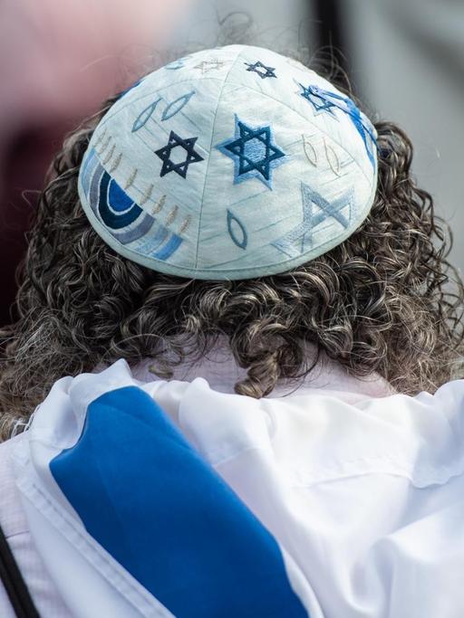 Eine Frau trägt auf einer Kundgebung eines Bündnisses gegen Antisemitismus in Hannover eine Kippa.