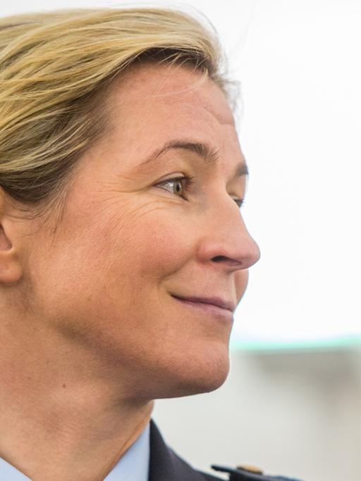 Claudia Pechstein in einem Sitzungssaal des Oberlandesgerichts. Sie lächelt.