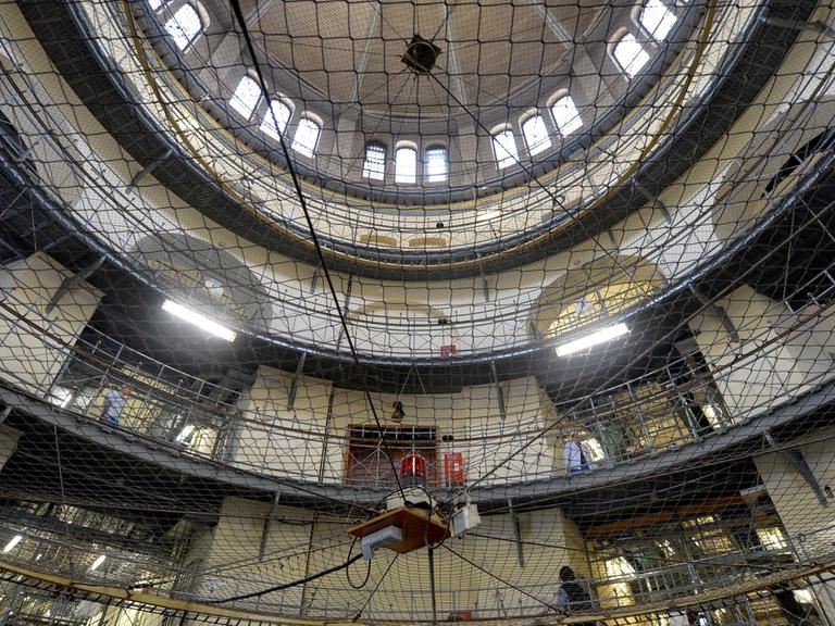 Häftlinge und Justizvollzugsbeamte stehen am 23.01.2014 in Berlin im Mittelbau der Justizvollzugsanstalt Moabit.