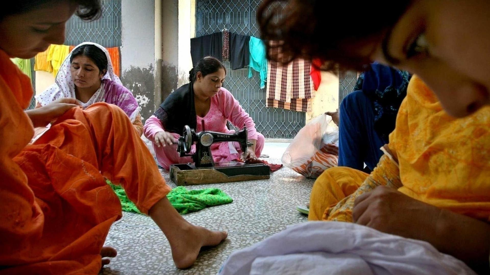 Frauen sitzen in einem Raum, in dem sie vor Männergewalt in Pakistan geschützt werden sollen