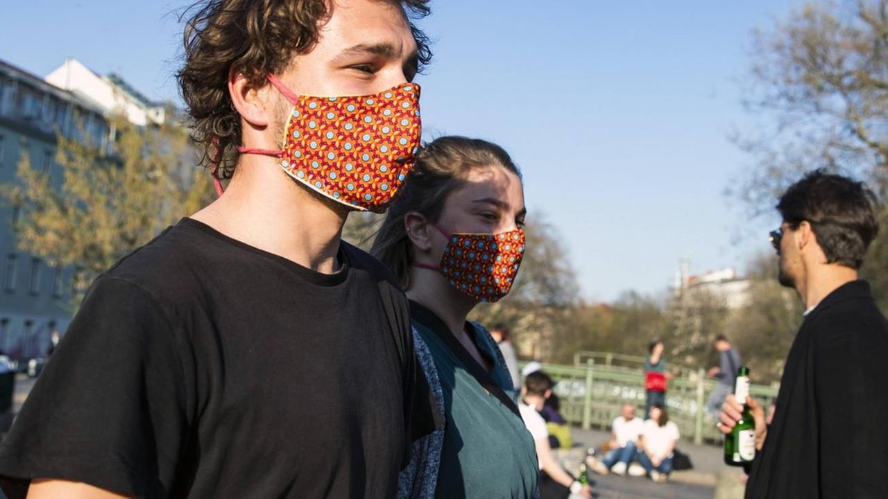Zwei Menschen tragen einen selbst-gemachten Mund-Schutz.