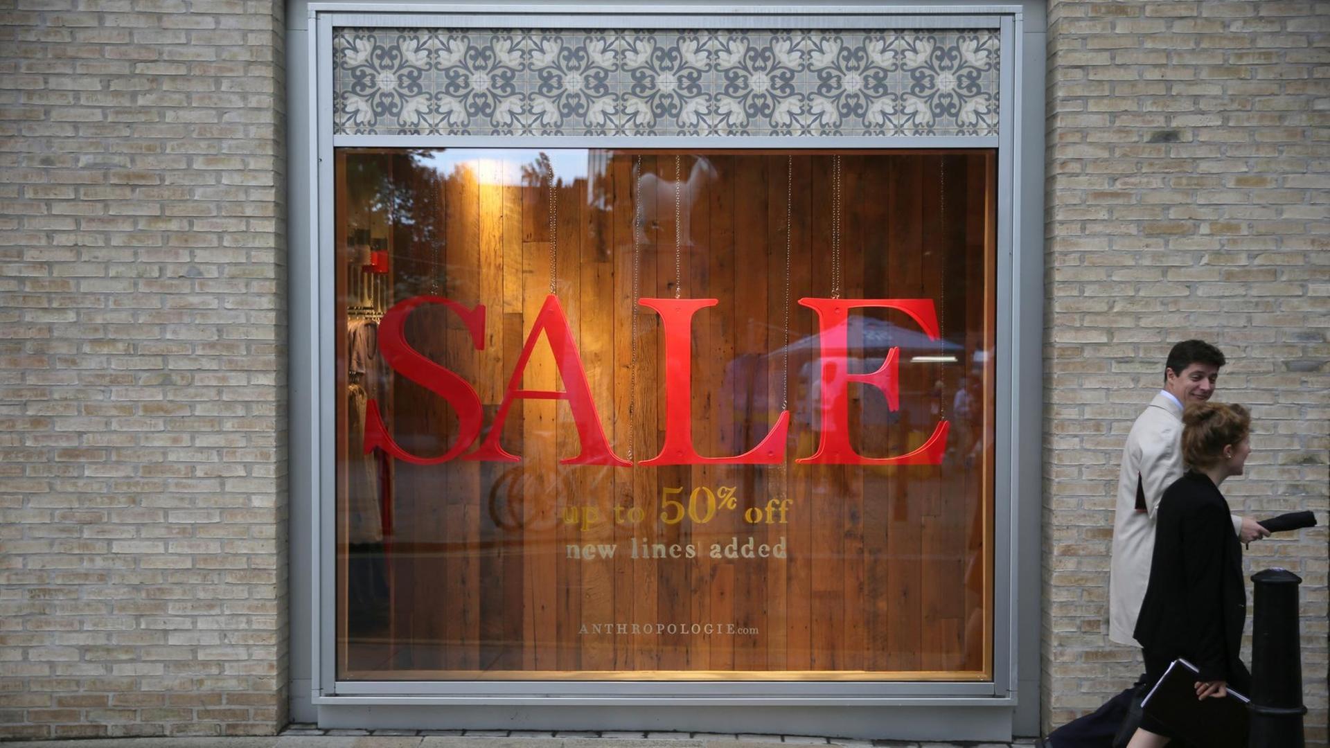 Ein Schaufenster in einer Fußgängerzone in England. Das Schaufenster ist leer und trägt den großen, roten Schritzug: "SALE". 