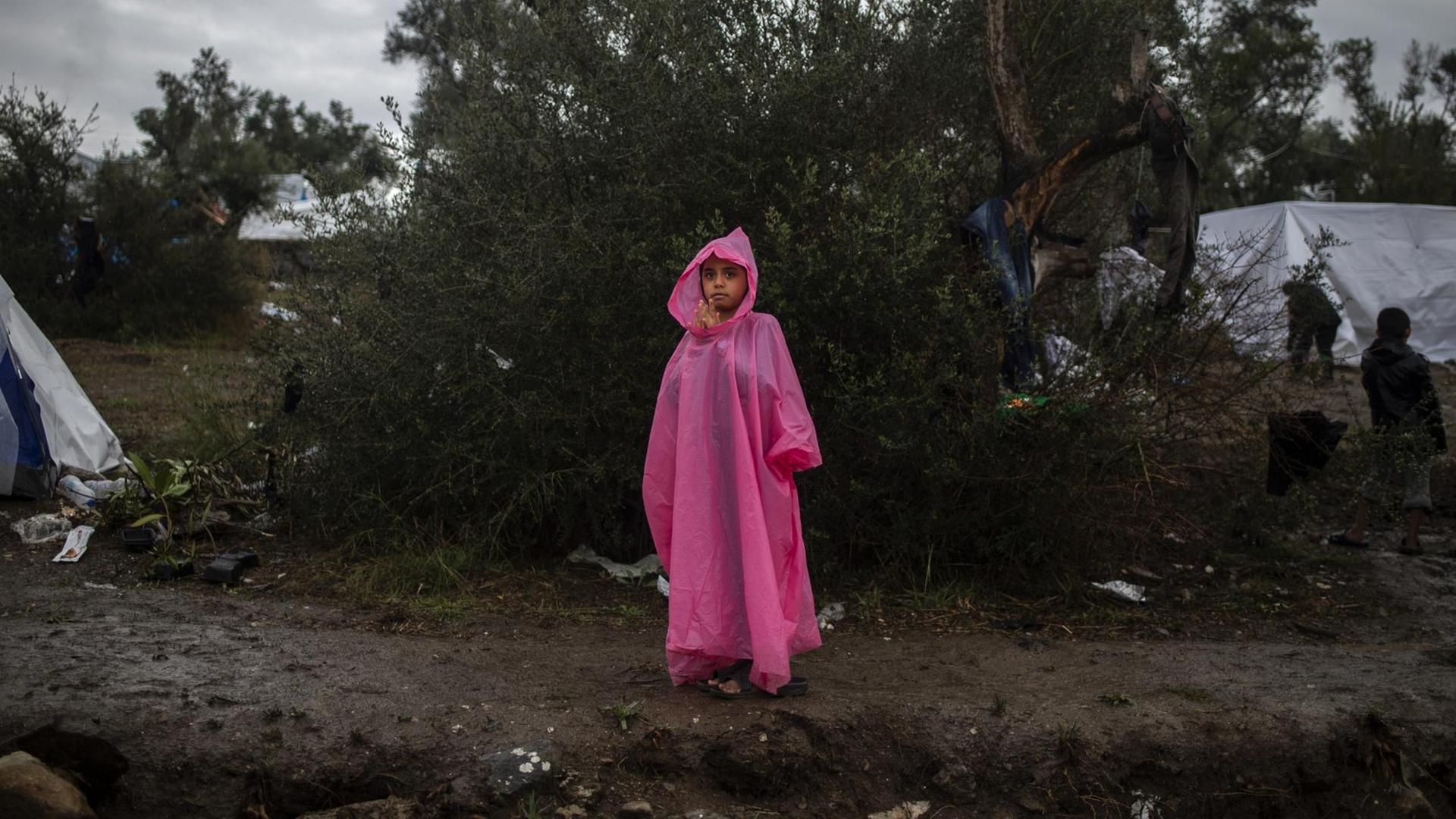 Ein Mädchen steht in einem provisorischen Lager neben dem Lager Moria auf der Insel Lesbos im Regen.