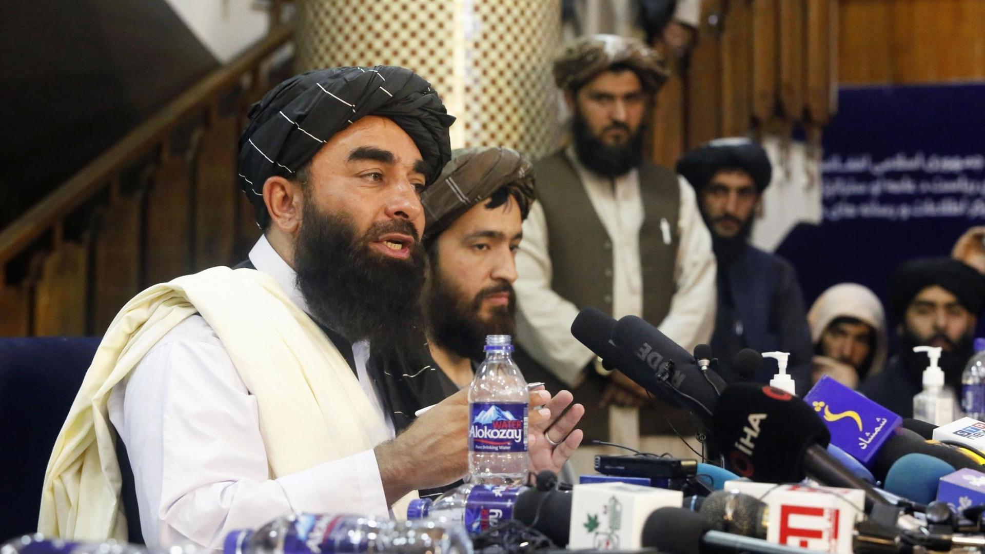 Taliban Sprecher Zabihullah Mujahid (links) auf der ersten Pressekonferenz der Taliban nach der Machtübernahme.