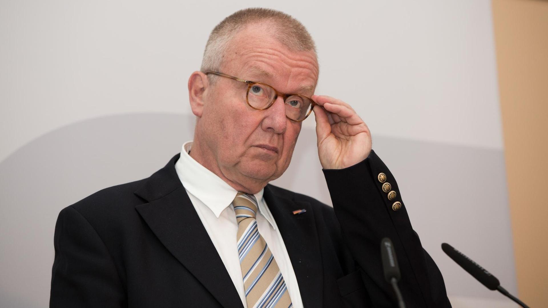 Das Bild zeigt Ruprecht Polenz, Präsident Deutsche Gesellschaft für Osteuropakunde. Er fasst sich vor grauem Hintergrund mit der linken Hand an seine Brille.