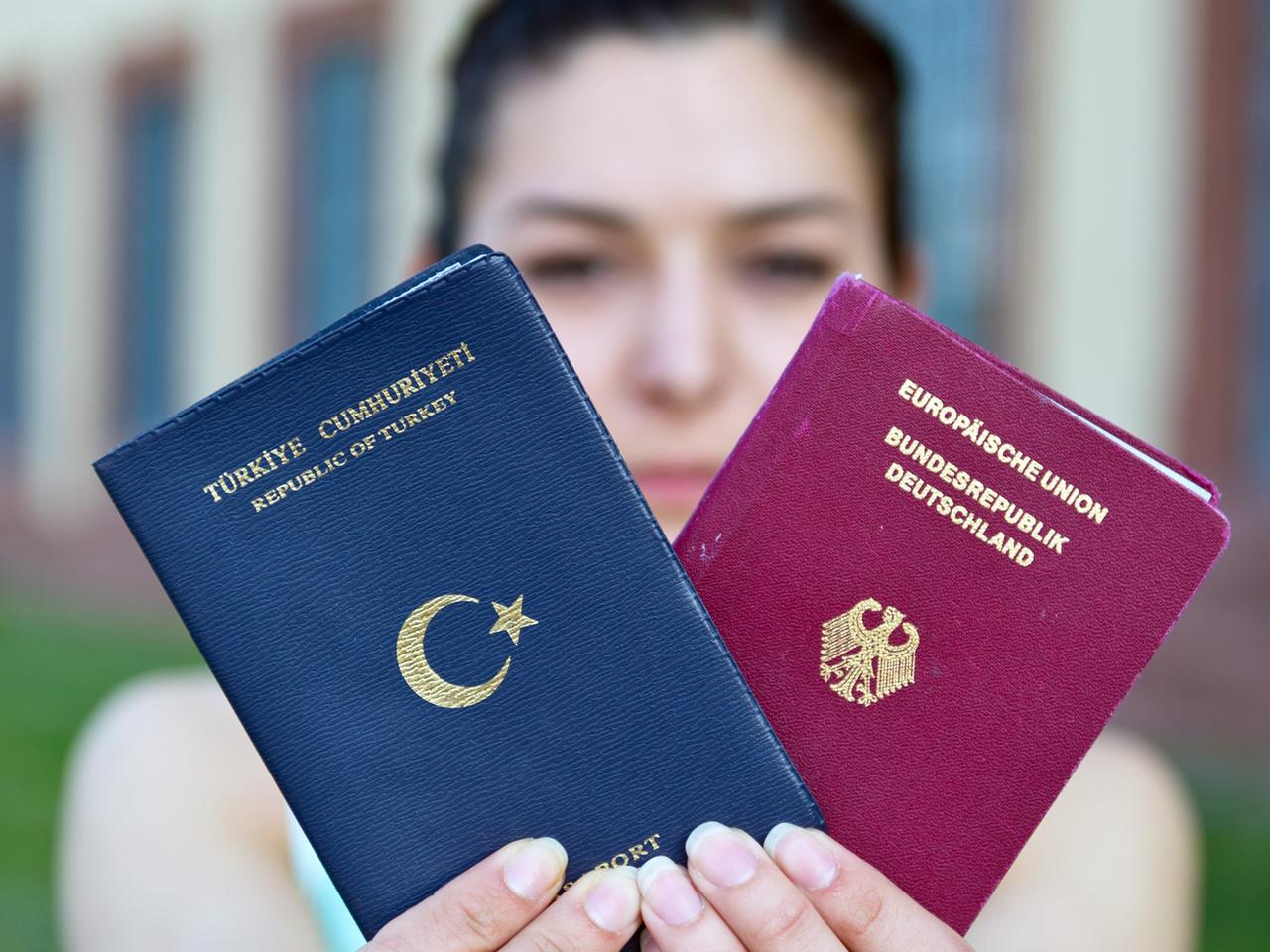 Eine Studentin zeigt einen türkischen Pass und einen deutschen Reisepass