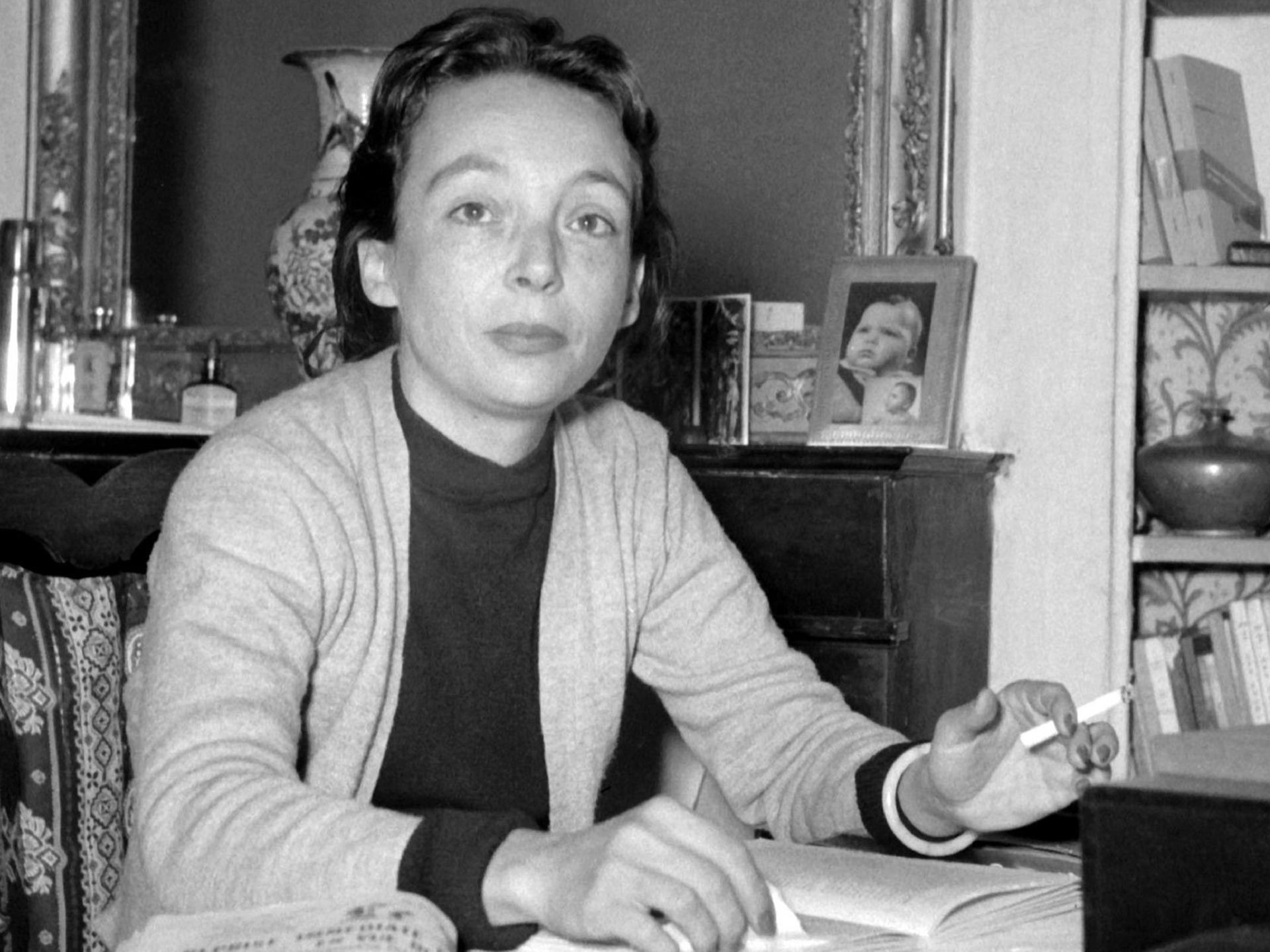 Die französische Schriftstellerin und Drehbuchautorin Marguerite Duras, aufgenommen an ihrem Schreibtisch in ihrer Wohnung in Paris in den frühen 50er Jahren.