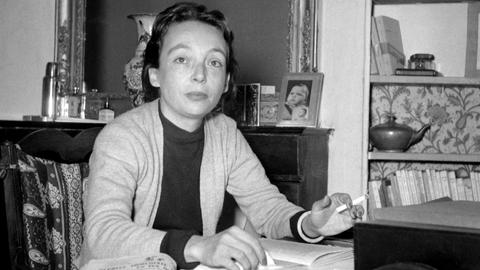 Die französische Schriftstellerin und Drehbuchautorin Marguerite Duras, aufgenommen an ihrem Schreibtisch in ihrer Wohnung in Paris in den frühen 50er Jahren.