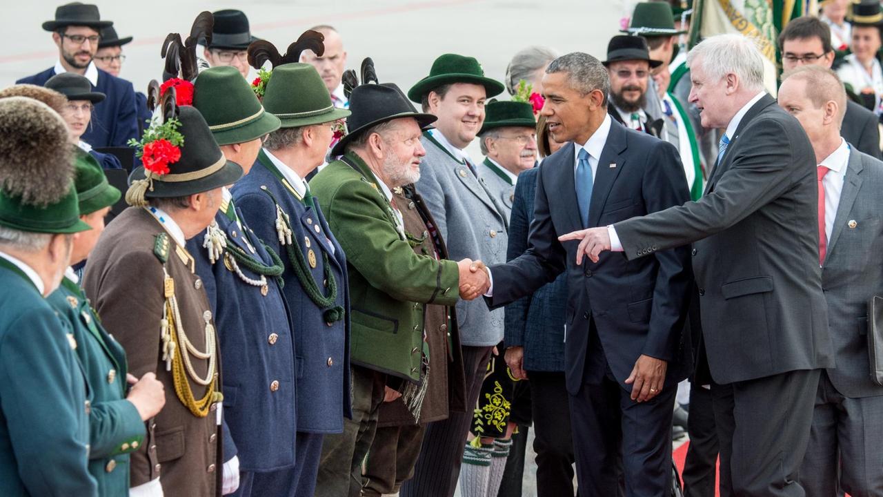 US-Präsident Barack Obama wird nach der Ankunft am Flughafen in München neben dem bayerischen Ministerpräsidenten Horst Seehofer von einer bayerischen Trachtengruppe begrüßt.